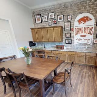 A cozy dining area featuring a wooden table and chairs, complemented by a brick wall adorned with various artworks and decor items.