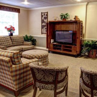 A cozy living room with patterned furniture and a television.