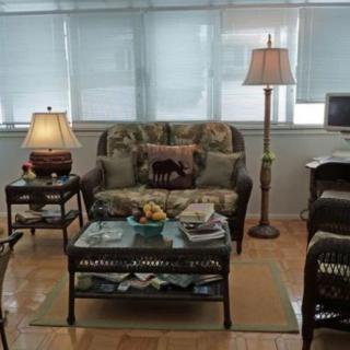 A cozy living room with a sofa, lamps, and a coffee table, decorated in a classic style.