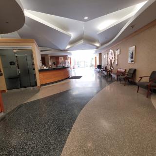A spacious and modern hospital lobby featuring a reception area and comfortable seating.