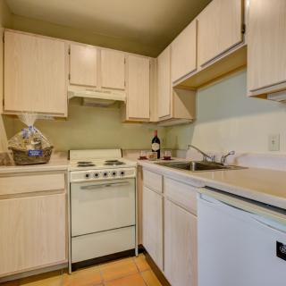 A compact kitchen with wooden cabinets and basic appliances.