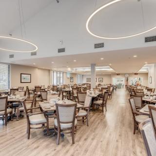 A modern and spacious dining area with an elegant interior design featuring round light fixtures and wooden flooring.
