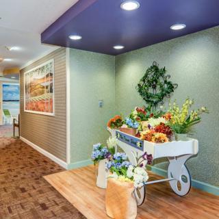 A well-decorated hallway with a flower cart and wreath.