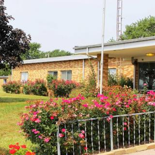 A picturesque building surrounded by a vibrant flower garden.