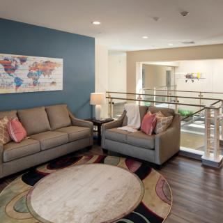 A modern living room with comfortable seating, colorful artwork, and a stylish rug.
