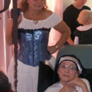 Two women in costume at an indoor event.