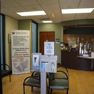 A medical clinic waiting room with seating and a reception desk.