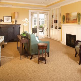 A cozy living room with warm yellow walls, a fireplace, and comfortable seating.