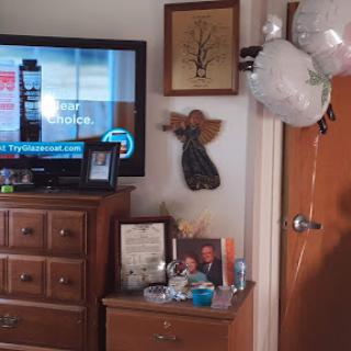 A cozy living room setup featuring a television, decorative items, and balloons.