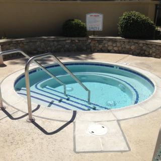 Outdoor hot tub with steps leading into the water.