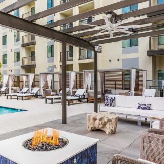 Modern outdoor lounge area with a fire pit, pool, and comfortable seating.
