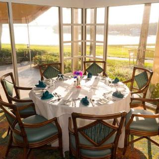 A beautifully set dining table near glass windows with a picturesque outdoor view.
