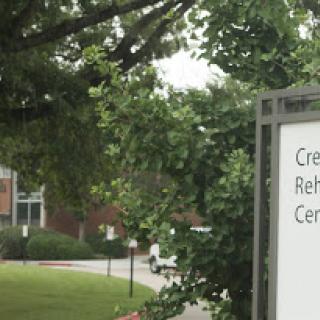A sign indicating the presence of a rehabilitation center, surrounded by greenery.