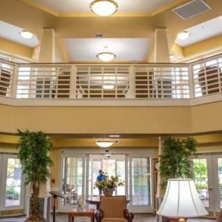 A well-lit lobby interior with comfortable furniture and decorative plants.