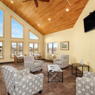 A modern living room with a high wooden ceiling, large windows, and stylish furniture.