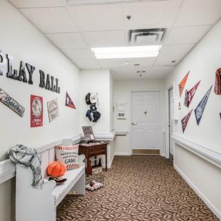 A hallway decorated with sports memorabilia and pennants, featuring a bench and various items related to baseball.