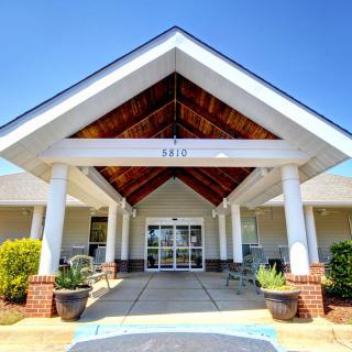 Front entrance of a building with an awning and columns.