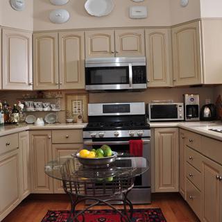 A cozy kitchen with modern appliances and a fruit bowl on the table.