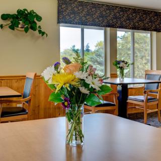 A cozy dining room with a vase of colorful flowers on the table.