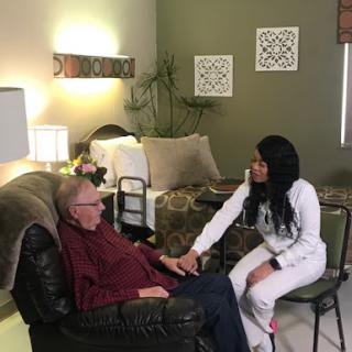 A caregiver gently interacts with an elderly gentleman in a cozy indoor setting, highlighting the importance of companionship and support.