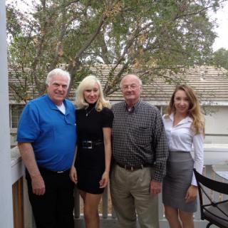 A cheerful gathering of four individuals posing together outdoors.