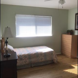 A minimalist bedroom with a single bed and natural light.