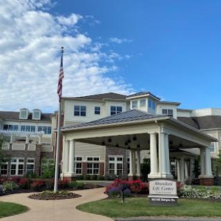 A welcoming community center featuring beautiful landscaping and an American flag.