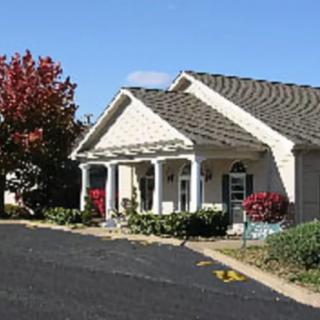 A suburban house with a landscaped yard and autumn foliage.