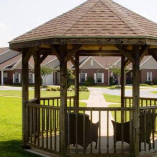 A wooden gazebo overlooking a suburban neighborhood with neatly trimmed lawns.