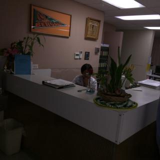 A receptionist sitting at a desk in an office environment.