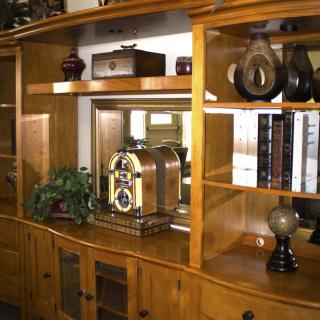 A wooden shelving unit adorned with decorative items, featuring a vintage radio and potted plant.