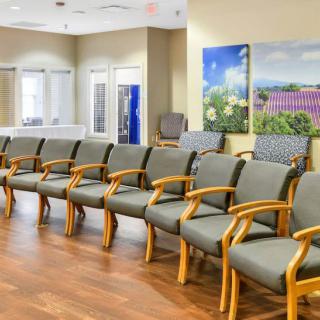 A spacious waiting room with multiple chairs lined up along the wall.