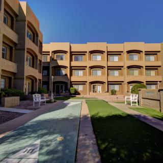 A view of a multi-story apartment complex with a central courtyard and pathway.