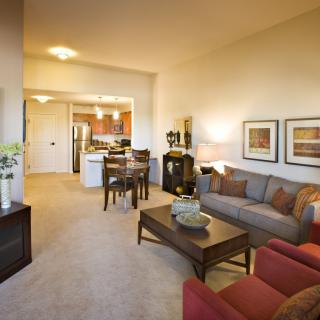 A cozy living room in a modern apartment with a sofa, dining table, and stylish decor.