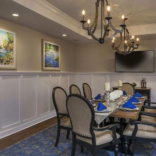 A well-decorated dining room with elegant chandeliers and a formal table setting.