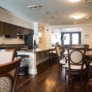 A modern kitchen and dining area with stylish wooden furniture and flooring.