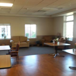 A spacious lounge area with comfortable seating and tables.