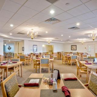 An empty restaurant dining room with neatly arranged tables and chairs.