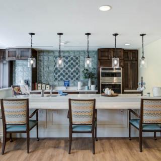 A modern kitchen with a large island, pendant lighting, and stylish bar stools.