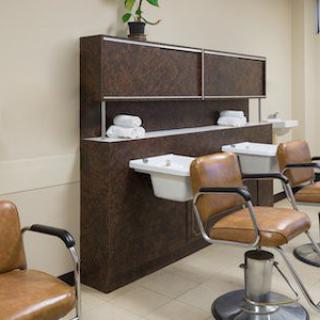 A modern hair salon interior with chairs and sinks for hair washing.