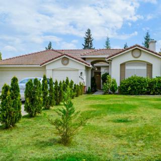 A suburban residential house with a well-maintained lawn and garden.