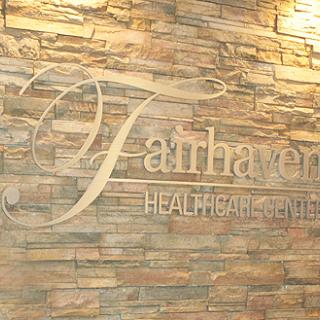 Interior signage for Fairhaven Healthcare, featuring a stylish design on a stone wall.