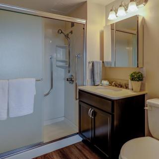 A modern bathroom with a glass-enclosed shower, elegant vanity, and cozy lighting.