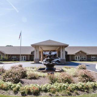 A welcoming entrance featuring a fountain and well-maintained landscaping.