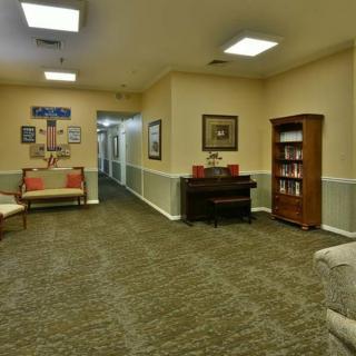 Cozy lobby with hallway, featuring seating and a bookshelf.