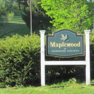 A community sign for Maplewood surrounded by lush greenery.