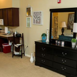 A cozy interior featuring a dresser with a mirror and home decor elements.