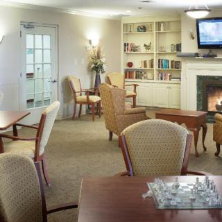 A cozy living room with a fireplace, bookshelf, and comfortable seating.