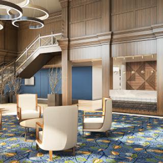 A stylish hotel lobby featuring modern furniture, a staircase, and elegant lighting.