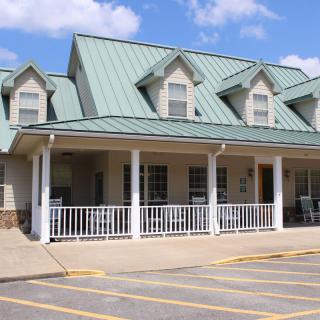 A quaint building with a green metal roof and a welcoming porch.
